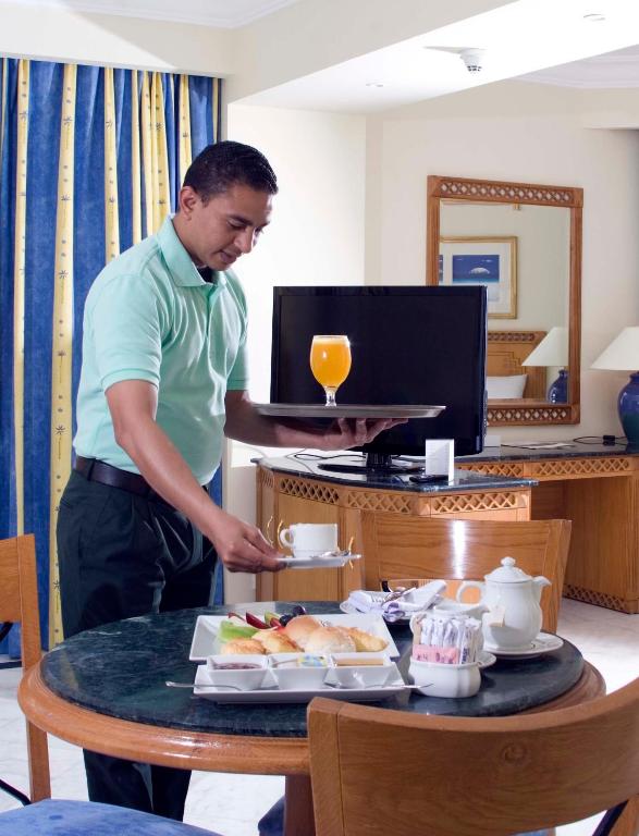 Viesmīlis pasniedz brokastis numurā Old Palace Resort Sahl Hasheesh.