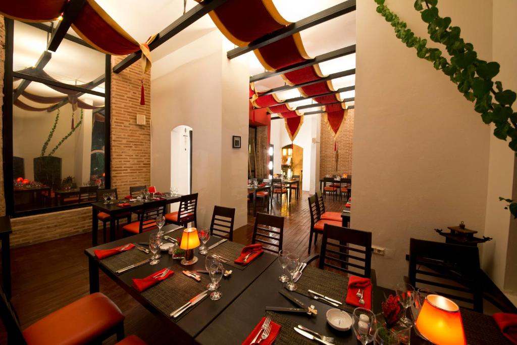 Restorāns Limak Arcadia Sport Resort ar elegantiem galdiem un siltu apgaismojumu.