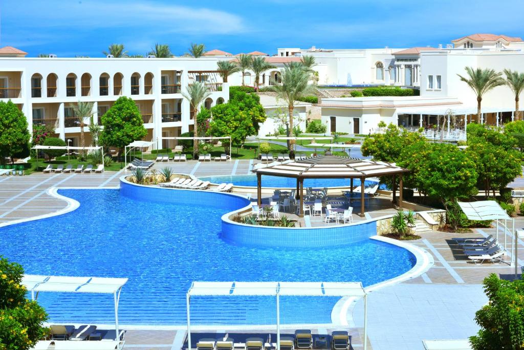 Viesnīcas Jaz Mirabel Beach baseins un apkārtne ar palmām.