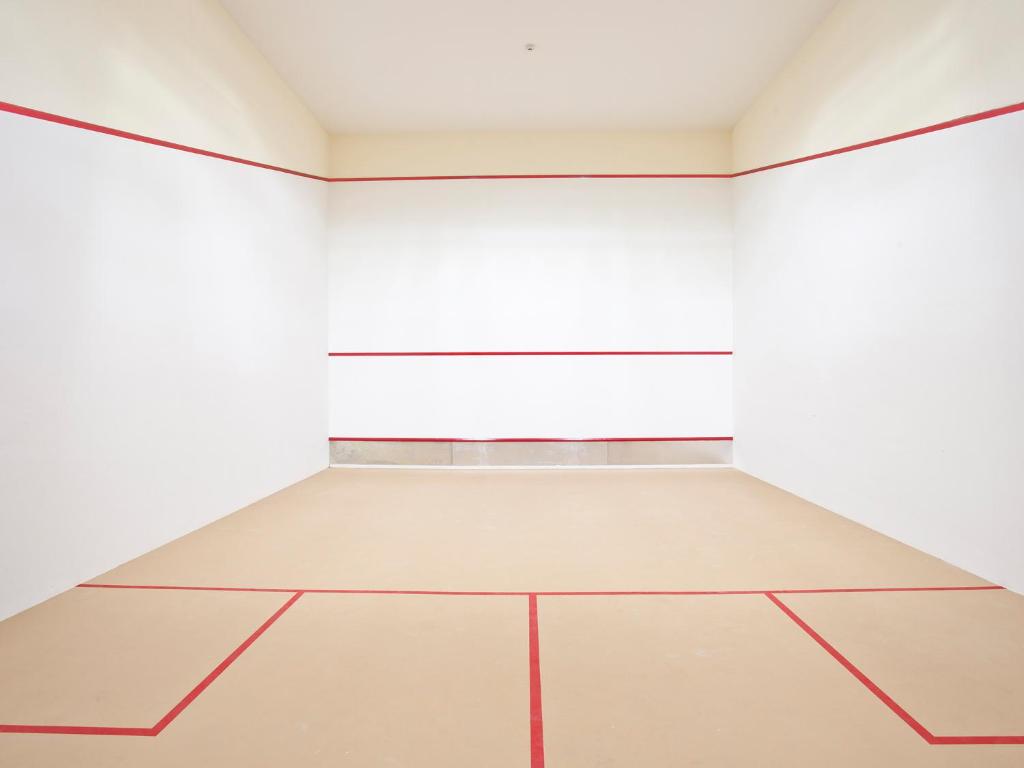 Squash laukums Graceland Khaolak Resort & Spa ar gludu grīdu un baltām sienām.