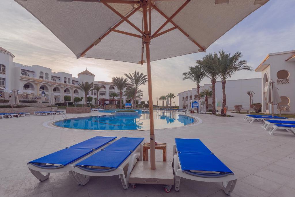 Peldbaseins ar sauļošanās krēsliem pie Old Palace Resort Sahl Hasheesh