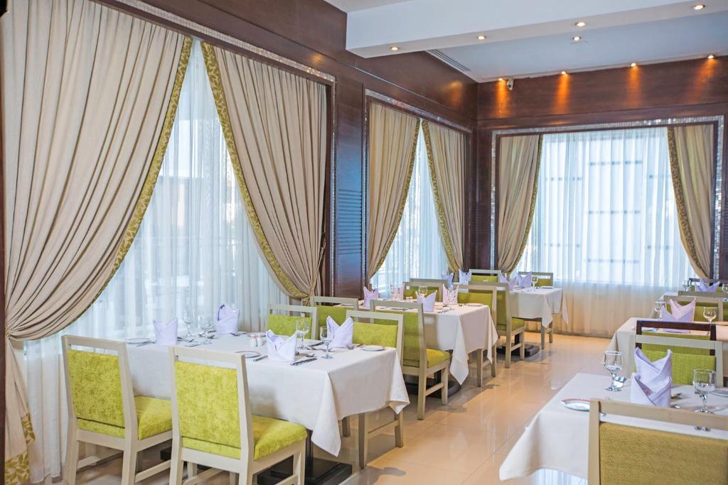 Elegantā restorāna interjers Sunrise Crystal Bay Resort ar zaļiem krēsliem.