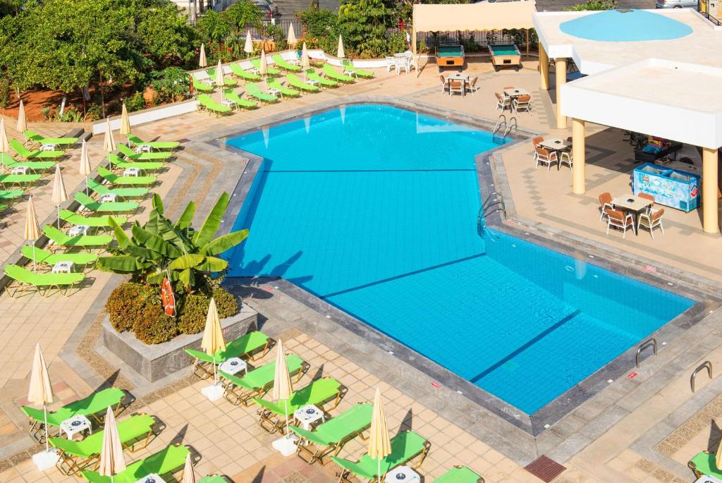 Peldbaseins ar skaidru zilu ūdeni, ap to izvietotas zaļas sauļošanās krēslus un saules laidiniekus. Apkārt peldbaseinam ir koka terase ar ēdamgaldiem un krēsliem, kā arī tropiski augi.