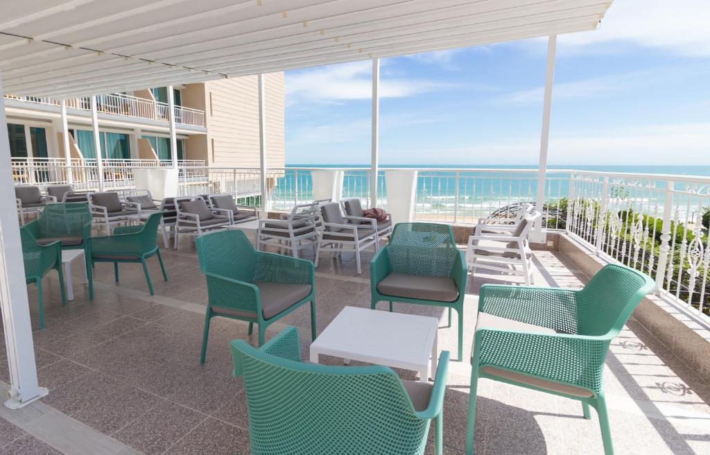 Terase ar modernām mēbelēm un skatu uz jūru, piedāvājot relaksējošu atmosfēru un komfortu. Ideāla vieta atpūtai un baudīšanai.