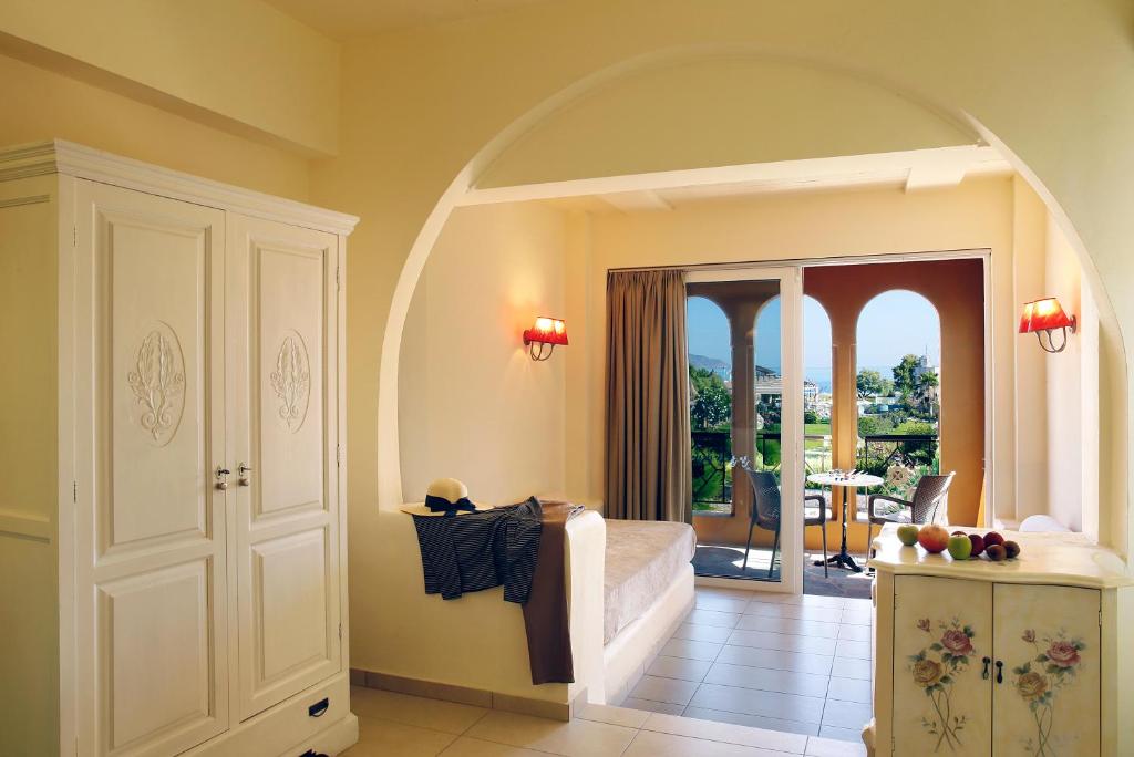 Tumšā krāsā izdekorēta istaba ar lieliem logiem, no kuriem paveras skats uz dārzu. Gaismas krāsas interjers ar ērtiem mēbelēm un gaismas ķermeņiem.