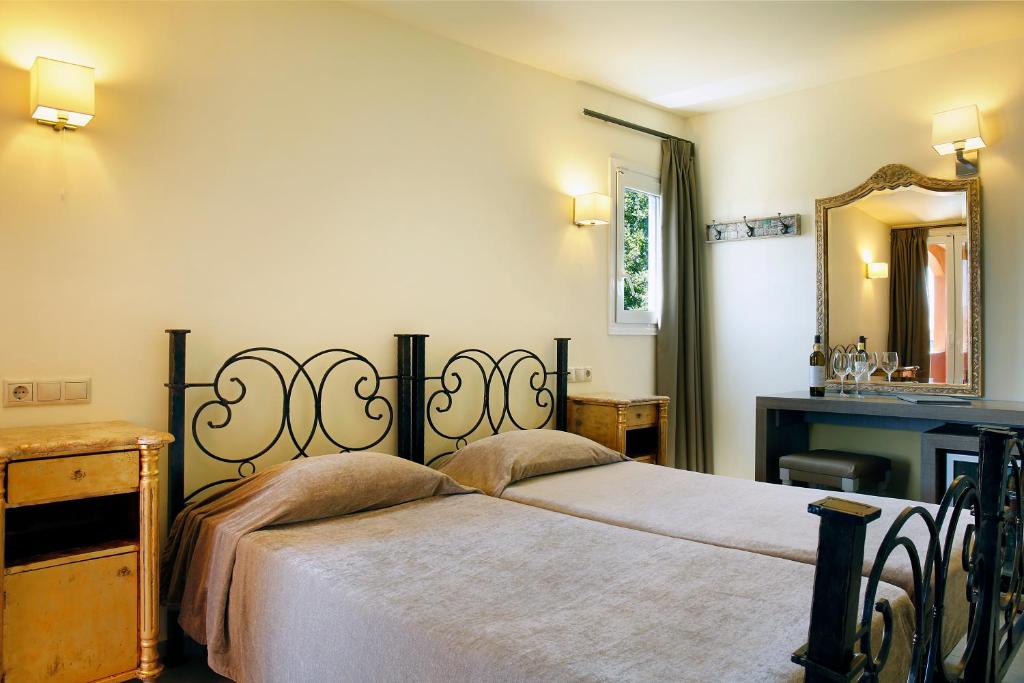 Mūsdienīgs guļamistabas interjers ar divām gultām, melnu metāla gultu un koka naktsgaldiņiem. Telpā ir liels spogulis un rakstāmgalds, radot elegantu un ērtu atmosfēru.