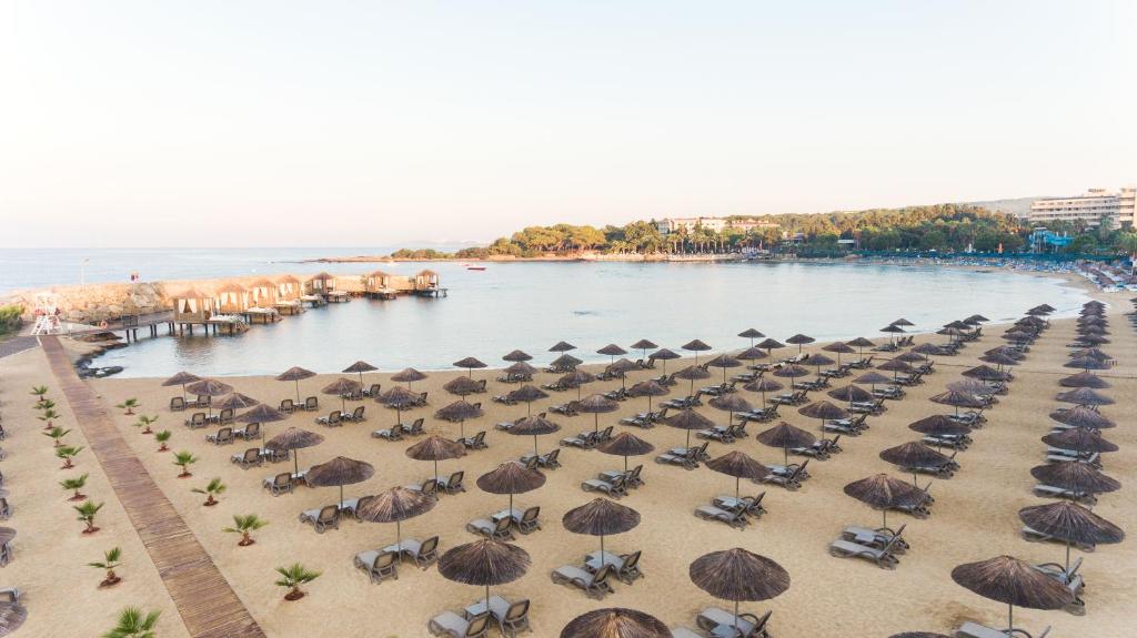Pludmale pie Rubi Platinum SPA Resort & Suites ar sauļošanās krēsliem un jumtiņiem.