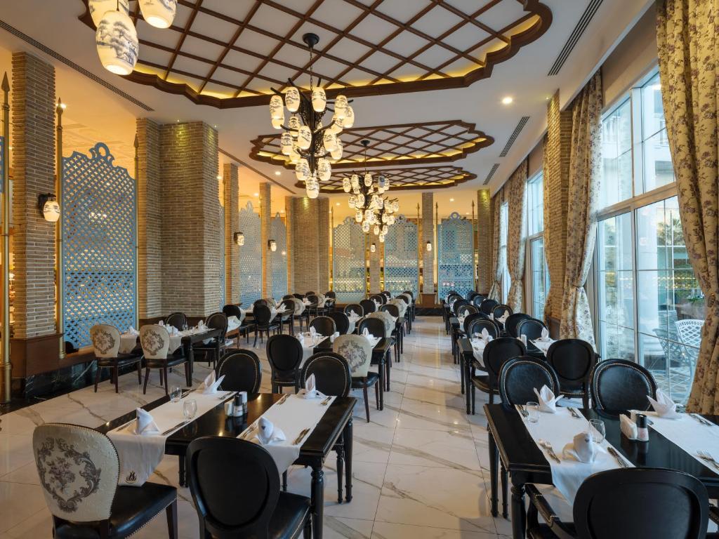 Rubi Platinum SPA Resort & Suites restorāns ar elegantiem galdiem un apgaismojumu.