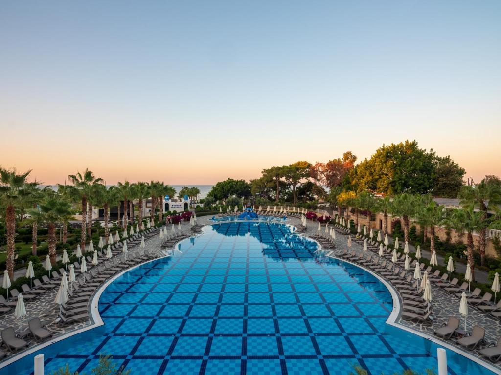 Rubi Platinum SPA Resort & Suites plašais baseins ar saulessargiem piekrastē.