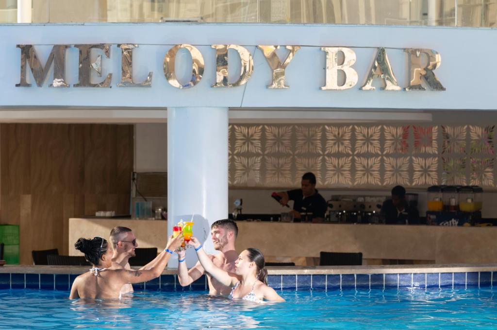 Grupas cilvēku dzērienu pacelšana pie Melody Bar Albatros Aqua Blu Resort
