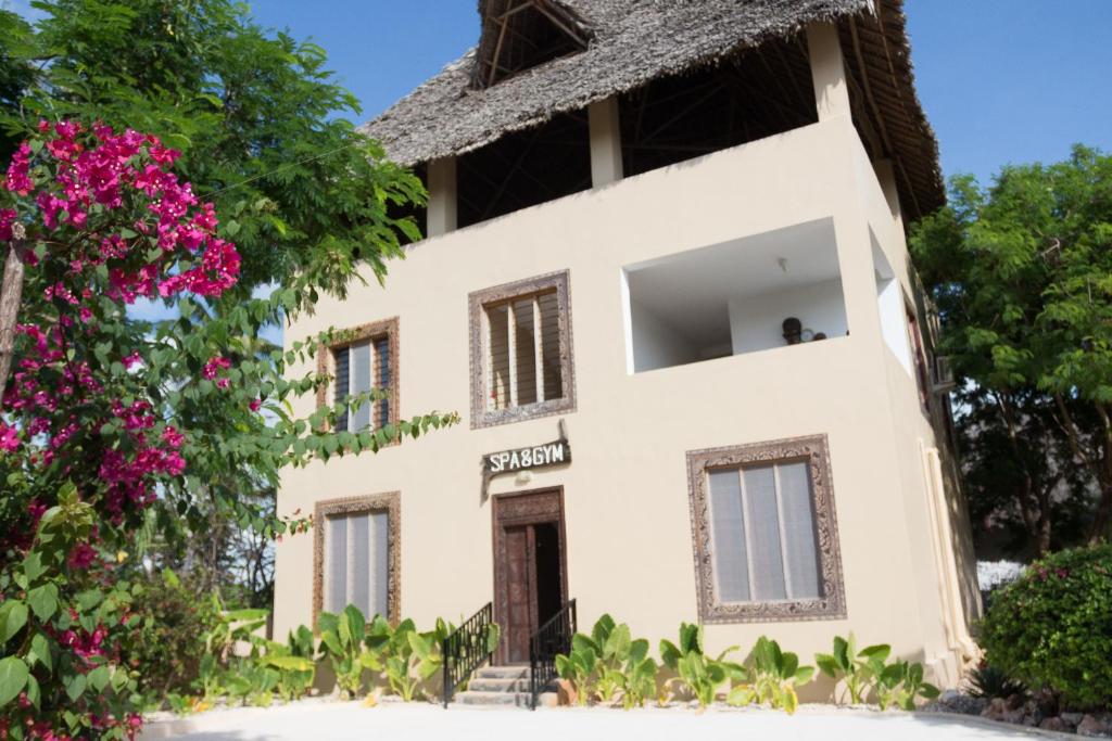 Reef & Beach Resort spa un sporta zāles ēka ar tropiskiem augiem priekšplānā.