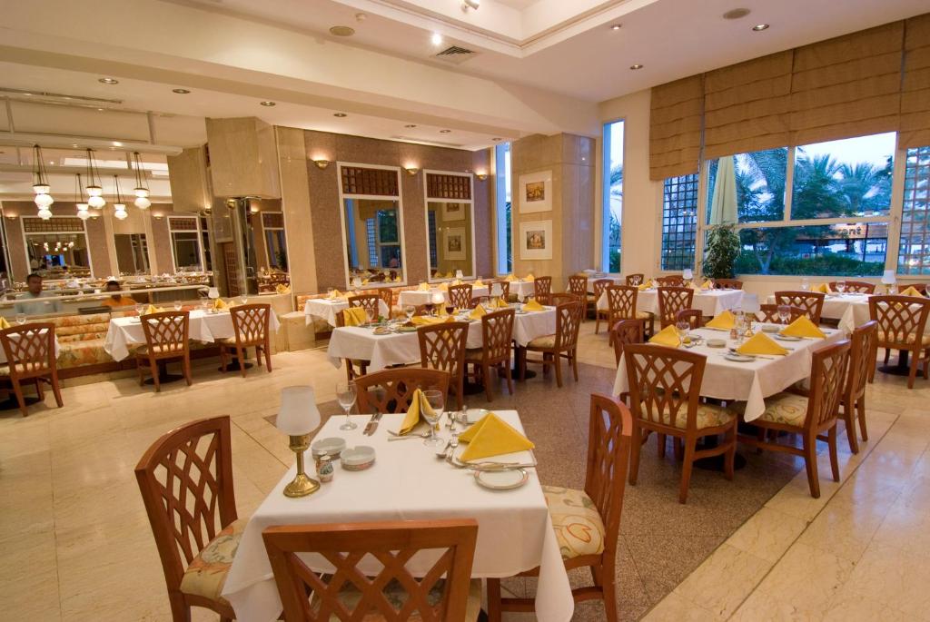 Restorāns Maritim Jolie Ville Resort & Casino ar elegantām galdiem un logiem.