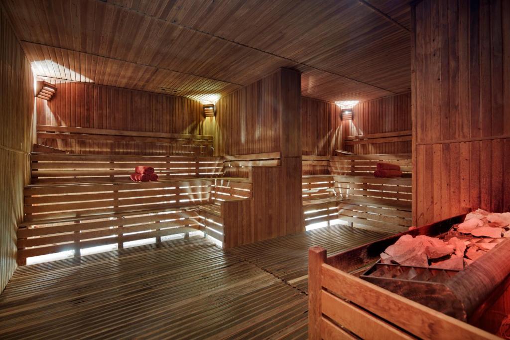 Alba Resort Hotel saunas interjers ar koka elementiem un sarkanām dvieļiem.