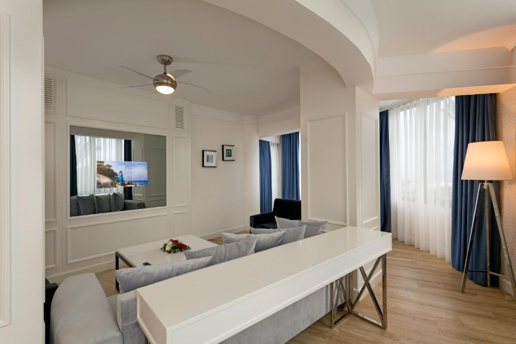 Mūsdienīgs dzīvojamais numurs Limak Atlantis De Luxe Hotel & Resort ar televizoru.