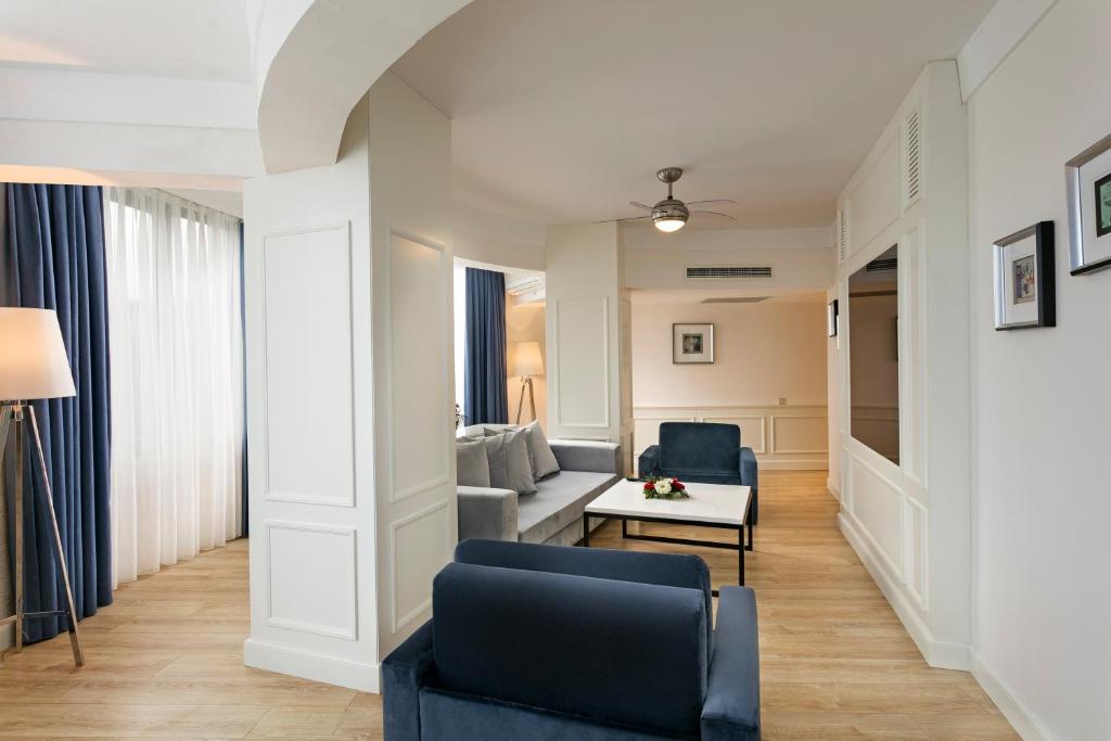 Mūsdienīgs viesnīcas numurs Limak Atlantis De Luxe Hotel & Resort ar dīvānu un galdu.