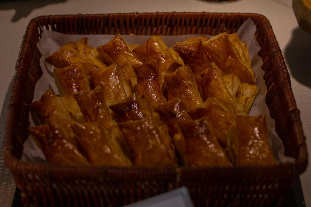 Izsmalcinātas pīrādziņas ar zeltainu garoza, pasniegtas groziņā. Ideāli piemērotas uzkodām vai svinībām.