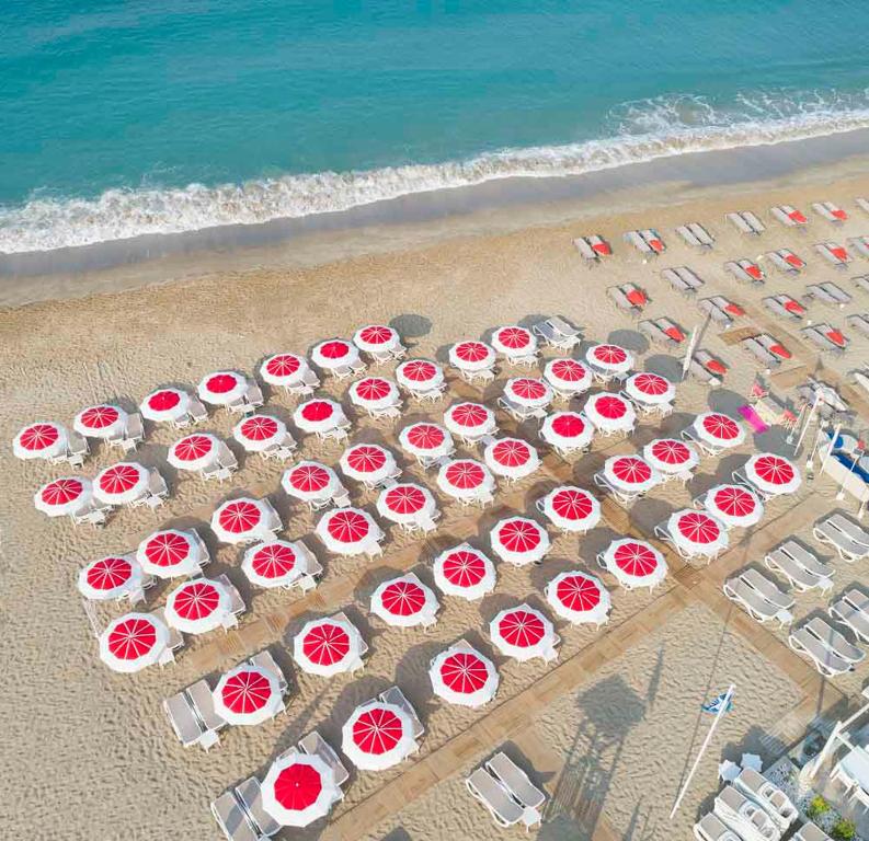 Pludmales sauļošanās krēsli un sarkanie lietussargi pie Xperia Saray Beach