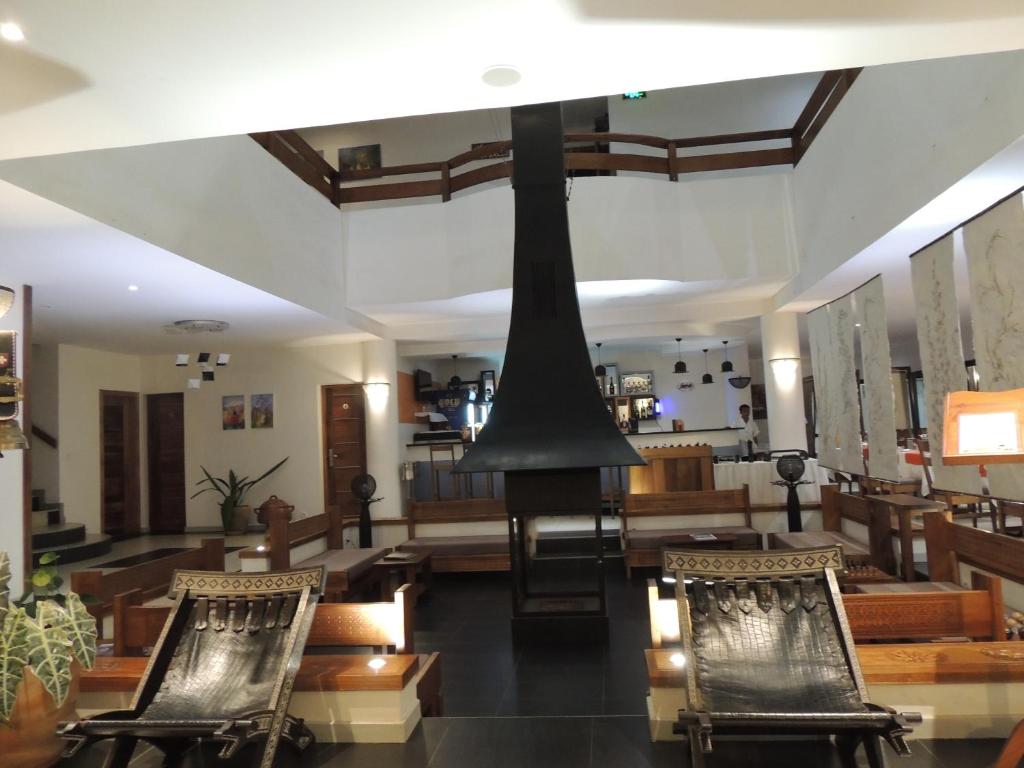 Hotel Plumeria viesnīcas vestibils ar modernām mēbelēm un kamīnu.