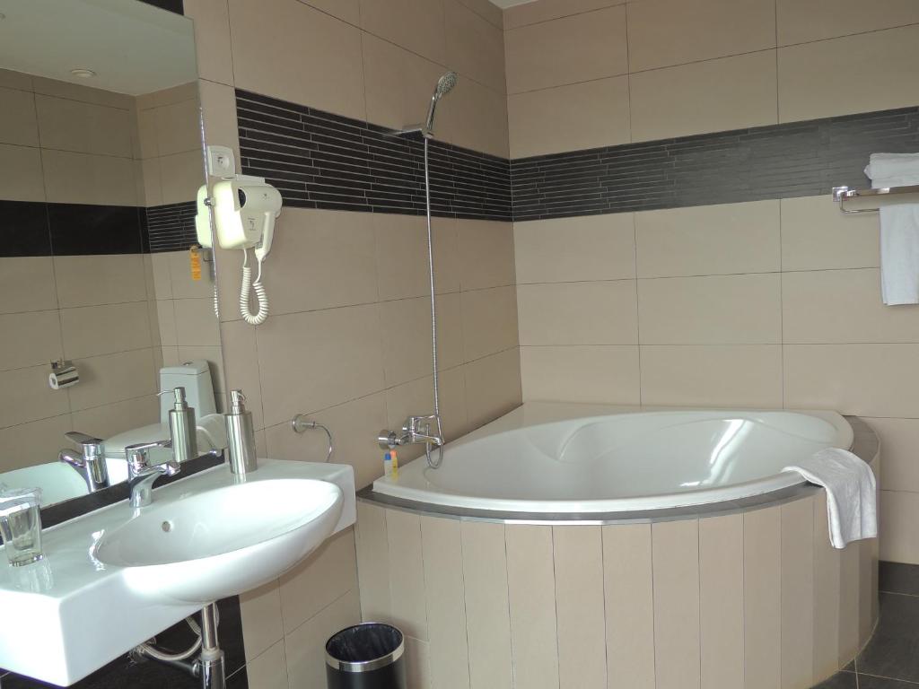 Moderns vannasistabas interjers Hotel Plumeria ar vannu un izlietni.