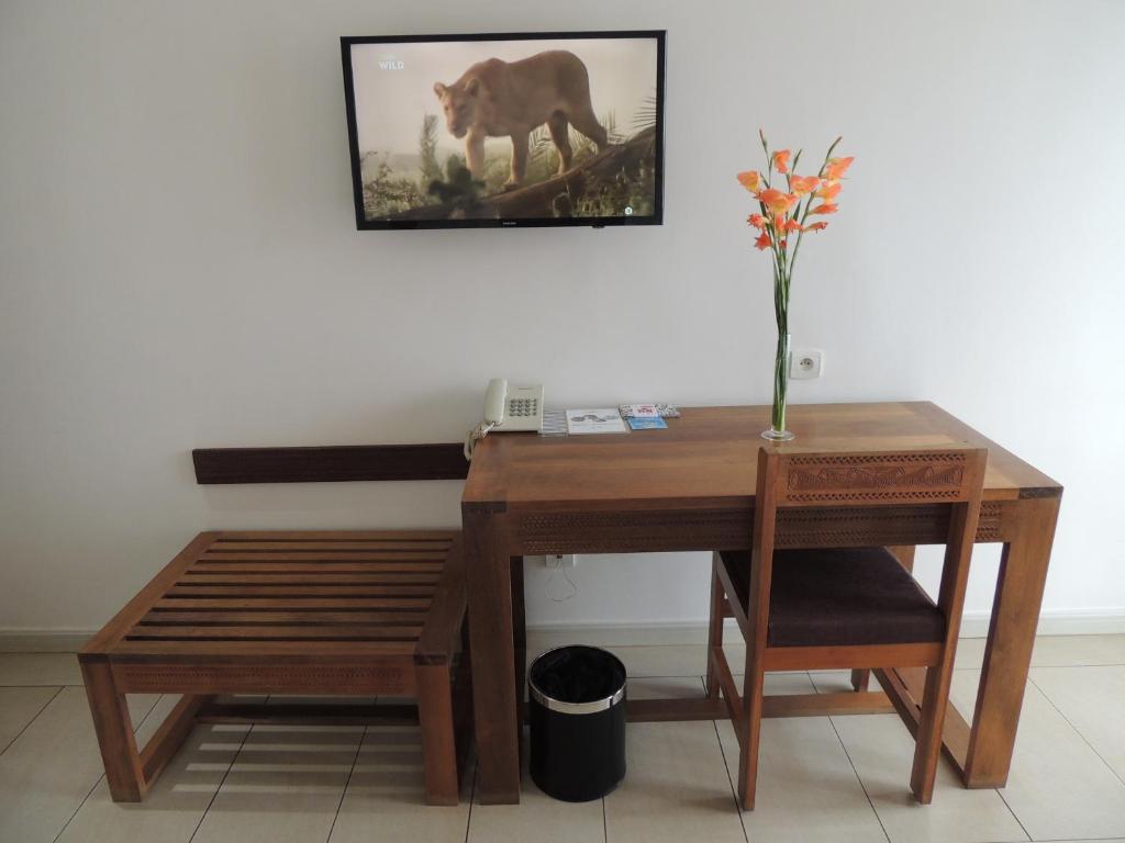 Hotel Plumeria numurs ar koka galdu un TV.