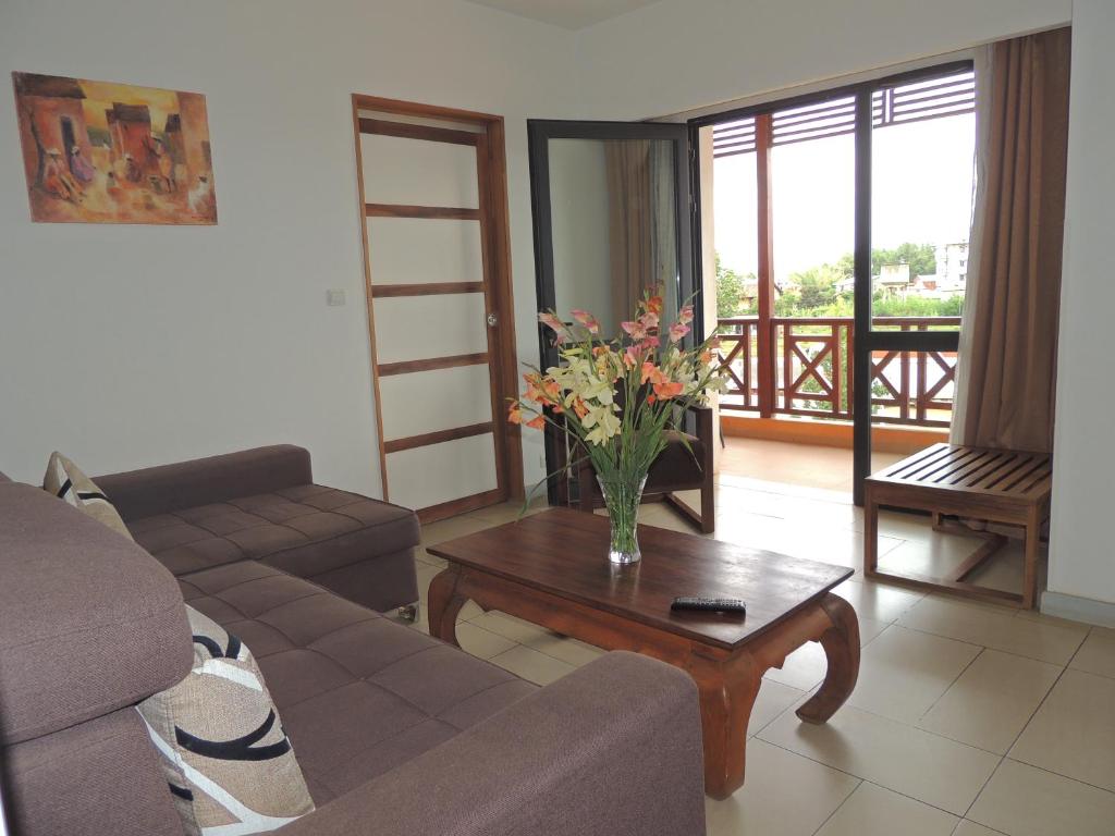 Hotel Plumeria viesnīcas numurs ar balkonu un dīvānu.