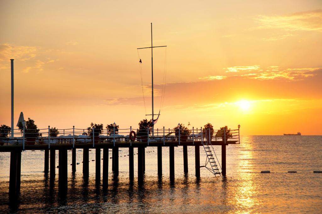 Saulriets pie Limak Limra Hotel & Resort mols, dzidrs ūdens un mierīga atmosfēra.