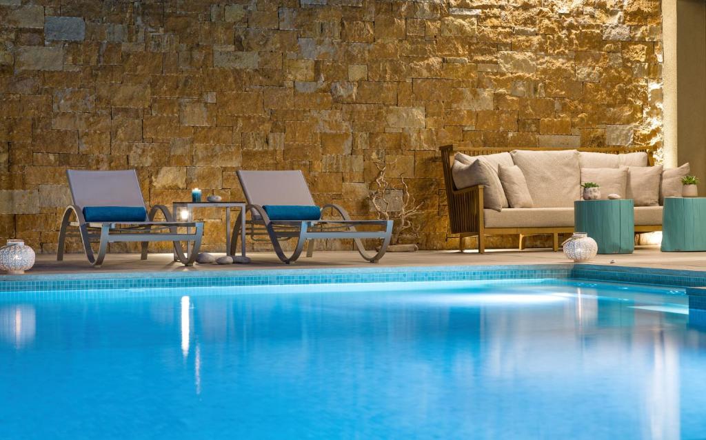 Mūsdienīgs peldbaseins ar ērtām atpūtas mēbelēm un akmens sienu fonu, radot relaksējošu atmosfēru. Ideāli piemērots brīvdienām vai atpūtai.