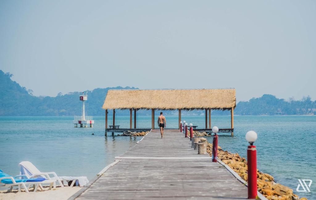Vīrietis dodas pa piekrastes piestātni The Aiyapura Koh Chang Resort