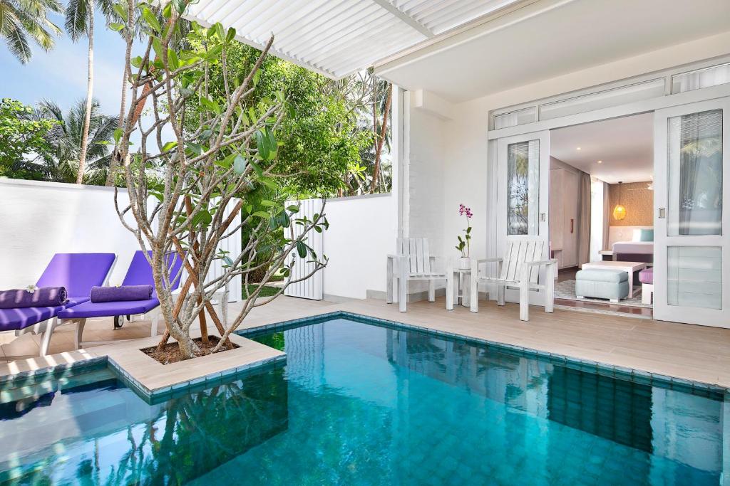 Skaista viesnīcas terase ar privātu baseinu, sēdvietām un tropisku augļu koku, kas nodrošina mierīgu atmosfēru. Ideāla vieta atpūtai un relaksācijai.