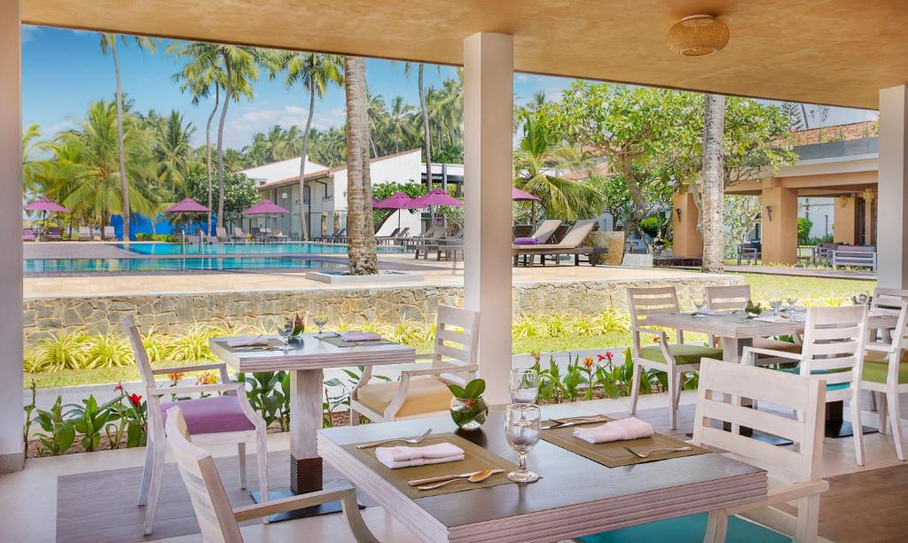 Moderns restorāns ar skatu uz baseinu un kokiem, apmeklētāji var izbaudīt relaksējošu atmosfēru. Elegantā iekārtojuma galdi un krēsli piesaista uzmanību.