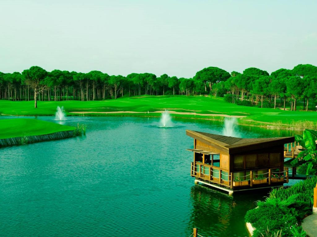 Zaļais golfa laukums un dīķis pie Sueno Hotels Golf Belek