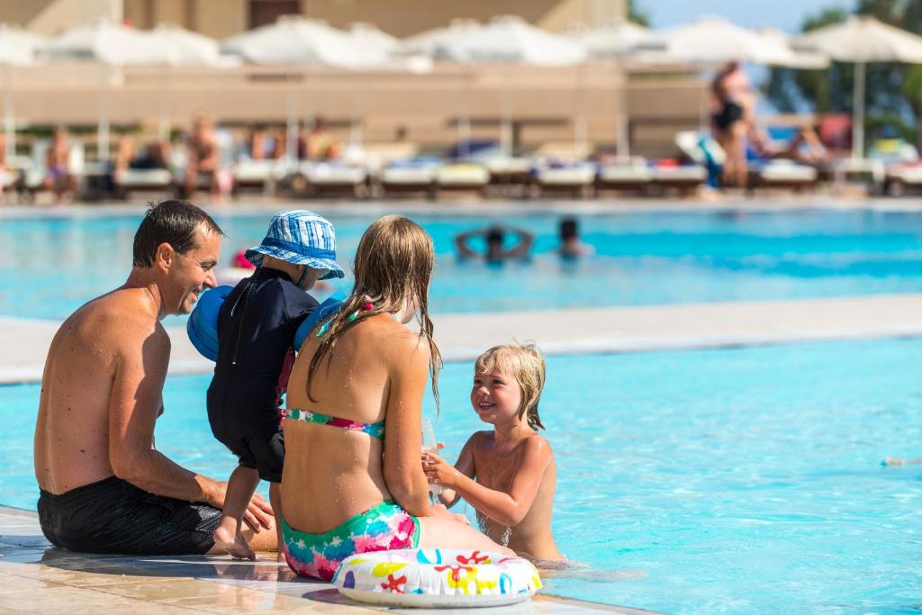 Ģimene izklaidējas pie baseina Sun Beach Resort.