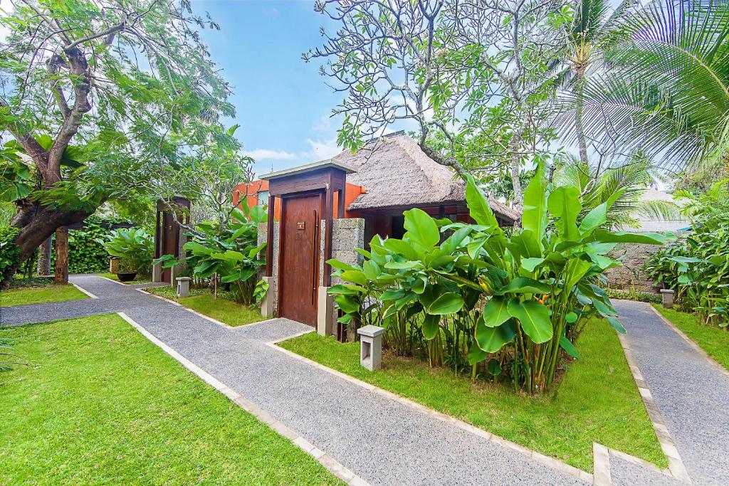 Ieeja uz numuriem pie Legian Beach viesnīcas, ieskauj zaļumi