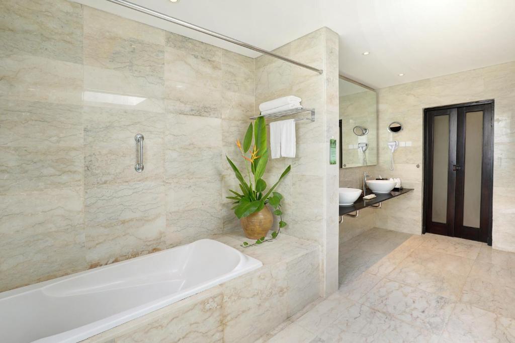 Mūsdienīgs un elegants vannas istaba viesnīcā Legian Beach ar vannu un dušu.