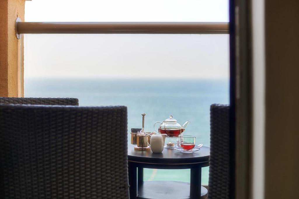Bahi Ajman Palace balkons ar tējas komplektu un skatu uz jūru