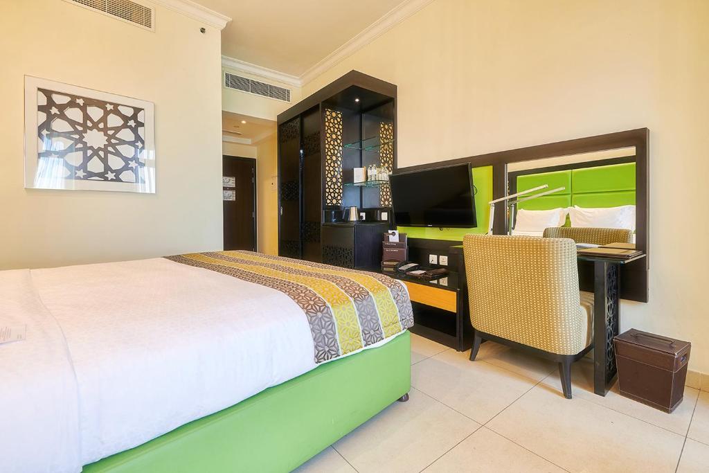 Mūsdienīgs numurs ar zaļu gultas rāmja dizainu viesnīcā Bahi Ajman Palace.