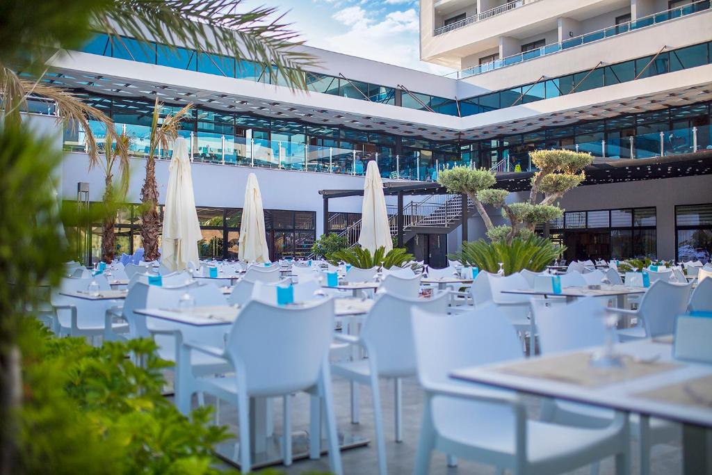 Moderns āra restorāns Numa Bay Exclusive Hotel ar baltām mēbelēm un palmām.