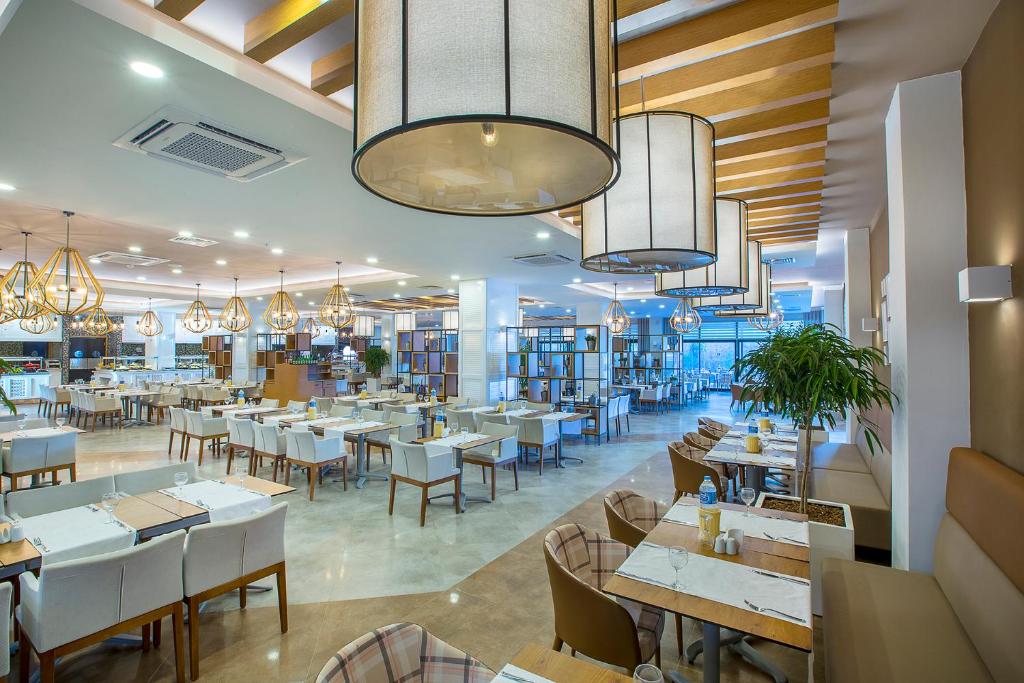 Mūsdienīgs restorāns Numa Bay Exclusive Hotel ar elegantiem lampām un plašām telpām.