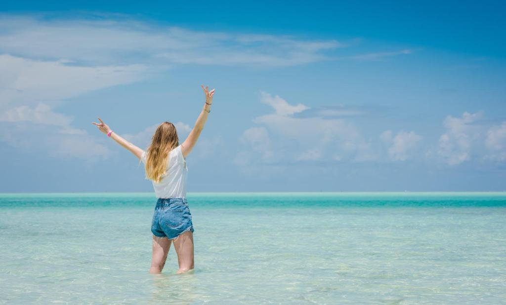 Sieviete pie okeāna pie Reef & Beach Resort.