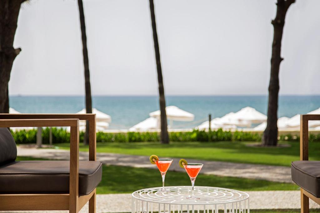 Divi kokteiļi uz galda pie Acanthus & Cennet Barut Collection ar skatu uz jūru.