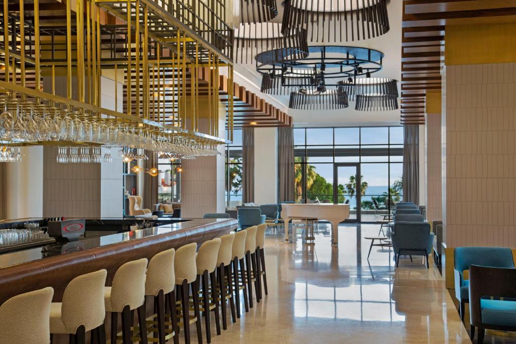 Acanthus & Cennet Barut Collection elegantā bāra interjers ar skatu uz piekrasti.