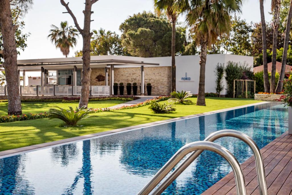 Acanthus & Cennet Barut Collection viesnīcas baseins ar zaļo zālienu un ēku fonā