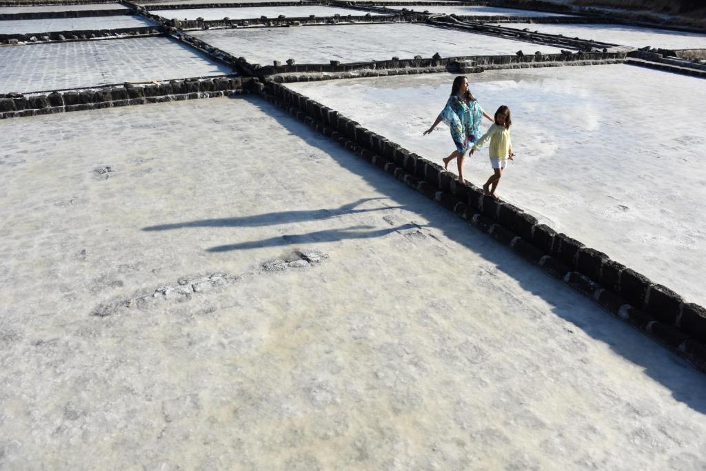 Divas personas staigā pa sāls laukiem pie Veranda Tamarin Hotel & Spa.