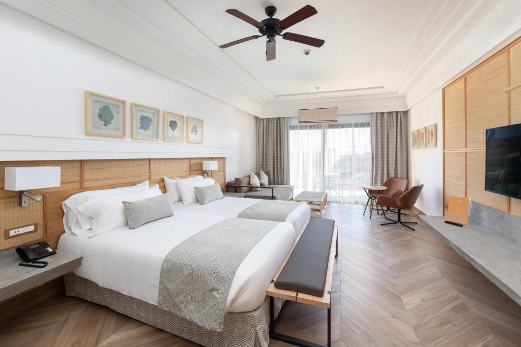 Mūsdienīgs viesnīcas numurs ar divām gultām, koka grīdu un plašu logu, kas nodrošina dabisko apgaismojumu. Interjers ir elegants, ar modernām mēbelēm un dekoratīviem elementiem.