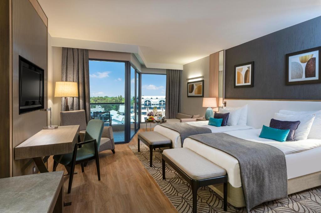 Mūsdienīgs numurs Susesi Luxury Resort ar balkonu un dabiskiem apgaismojumiem.
