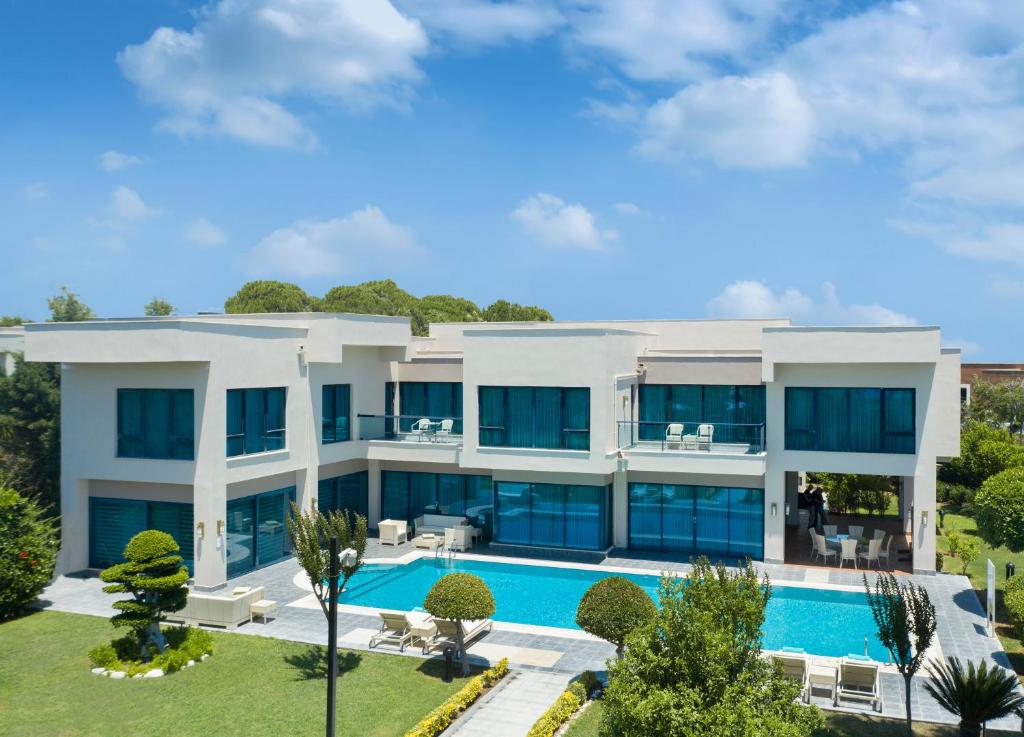 Susesi Luxury Resort moderno numuru komplekss ar baseinu un bieziem dārziem.