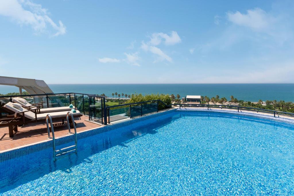 Susesi Luxury Resort baseina skats ar jūru fona