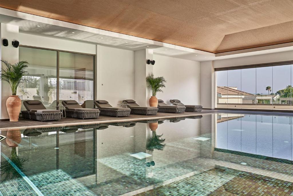 Mare Ayia Napa viesnīcas iekštelpu baseins ar atpūtas krēsliem.