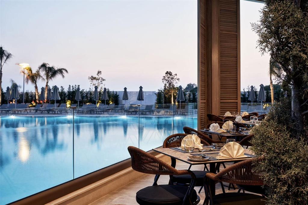 Restorāns pie baseina Mare Ayia Napa viesnīcā saulrietā.