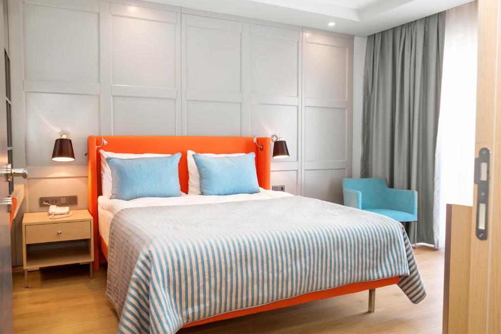 Moderns numurs ar spilgtu oranžu gultu Numa Bay Exclusive Hotel.